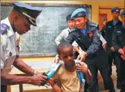  ??  ?? A student receives a schoolbag donated by UN personnel in Montserrad­o, Liberia.