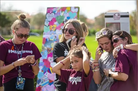  ?? Saul Martinez/The New York Times ?? People gather Thursday in Pine Trails Park near Marjory Stoneman Douglas High School to honor victims of the shooting one year ago at the school in Parkland, Fla. On a day nobody wanted to remember — or forget — Parkland students observed a day of mourning for the 17 lives lost.