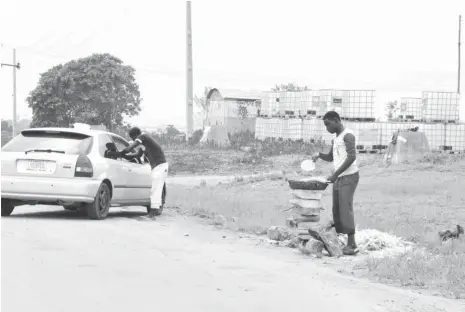  ?? PHOTO: Ikechukwu Ibe ?? A motorist buys roasted corn along Abuja Airport road recently