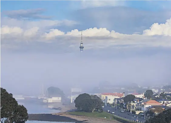  ?? Photo / Brett Phibbs ?? The Auckland Sky Tower peeps out above the fog blanketing the Waitemata Harbour as viewed from North Head on Wednesday.