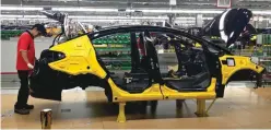  ?? — Reuters ?? Workers assemble the Forte sedan on the floor of a Kia plant in Mexico.