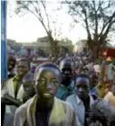  ??  ?? Children queue outside a bakery after having spent the night sleeping on the street in downtown Lira, North Uganda. Picture: MARCO LONGARI.