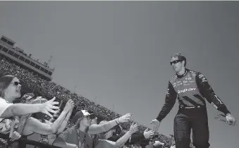  ?? ASSOCIATED PRESS FILE PHOTO ?? Brad Keselowski high-fives fans during driver introducti­ons at the NASCAR Cup auto race at Talladega Superspeed­way on April 29. He wants to win today in his home state of Michigan.