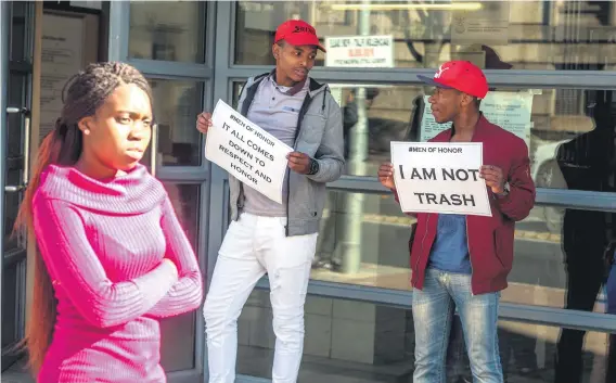  ?? Picture: Yeshiel Panchia ?? HONOUR. A woman walks past two men – Siyabonga Mabizela and Donovan Mncube – outside court yesterday.