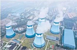  ?? CHINATOPIX ?? Steam billows from cooling towers at a coal-fired power station Sept. 27 in Nanjing, China. The world is in an energy crunch as winter looms and the pandemic continues.