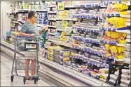  ?? Associated Press ?? A shopper looks at an item in the dairy section of a Kroger grocery store in Richardson, Texas.