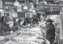  ?? PROVIDED TO CHINA DAILY ?? Consumers gather at a stall at a food market in Harbin in February.