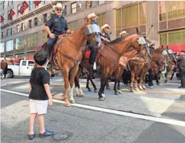  ?? JACK GRUBER, USA TODAY ?? Marzooug, 6, from Kuwait, visiting Cleveland with his family, stops to admire the police mounted patrol.