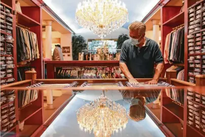  ?? Jon Shapley / Staff photograph­er ?? Hossein Taghi, A Taghi Fine Apparel & Shoes co-owner, organizes the store Tuesday ahead of a planned reopening.