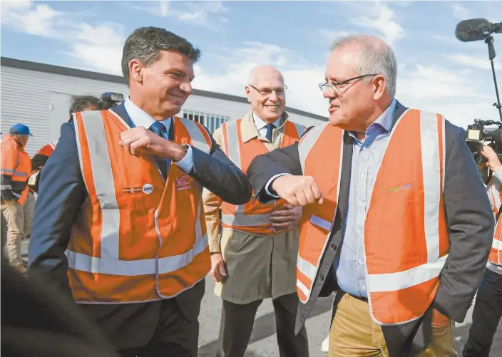  ?? AAP Image / Lukas Coch ?? Energy and Emissions Reduction Minister Angus Taylor and Prime Minister Scott Morrison greet each other on a visit to the Snowy 2.0 Polo Flat segment factory in Cooma, NSW, in June.