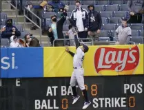  ?? FRANK FRANKLIN II - THE ASSOCIATED PRESS ?? A fan catches a ball hit by Tampa Bay Rays’ Francisco Mejia for a home run as New York Yankees right fielder Aaron Judge (99) leaps at the wall during the second inning of a baseball game Saturday, April 17, 2021, in New York.