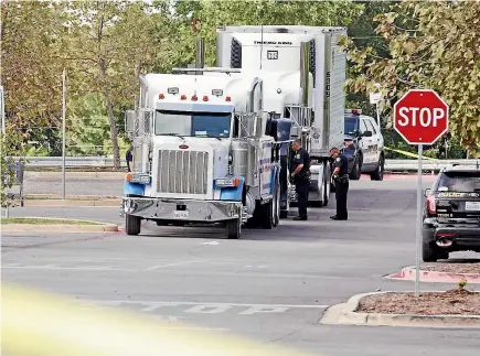  ?? PHOTO: REUTERS ?? Police officers work on a crime scene after eight people, believed to be illegal immigrants being smuggled into the United States, were found dead inside a sweltering 18-wheeler truck and trailer parked behind a Walmart store in San Antonio, Texas.