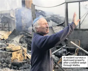  ??  ?? A resident surveys a destroyed property after a wildfire swept through Malibu