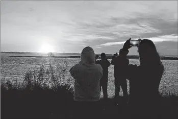  ??  ?? Spectators in Chincoteag­ue, Va., watch the fireball from the explosion of the unmanned Orbital Sciences Corp.’s Antares rocket and Cygnus cargo capsule seconds after liftoff Tuesday from Wallops Island, Va. No injuries were reported following the first...