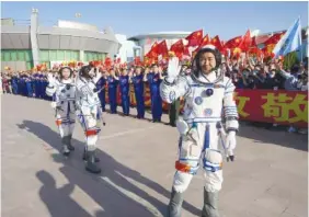  ?? LI GANG/XINHUA NEWS AGENCY VIA AP ?? Chinese astronaut Chen Dong, right, walks ahead of fellow astronauts Liu Yang and Cai Xuzhe during a sendoff ceremony Sunday for the Shenzhou-14 crewed space mission at the Jiuquan Satellite Launch Center in northweste­rn China.