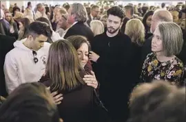  ?? Patrick T. Fallon For The Times ?? LORRIE DINGMAN is embraced at a service Saturday for her son Blake and his friend Jake Dunham, who were killed in the Nov. 7 shooting in Thousand Oaks.