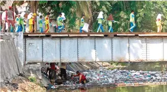  ?? AHMAD KHUSAINI/JAWA POS ?? MENUMPUK: Sebanyak 250 orang dari berbagai instansi bekerja sama membersihk­an sampah di Kali Pegirian kemarin.