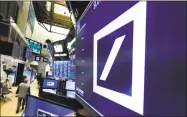  ?? Associated Press ?? The logo for Deutsche Bank above a post on the floor of the New York Stock Exchange. German authoritie­s suspect that Deutsche Bank employees helped clients set up offshore companies in tax havens to launder hundreds of millions of euros.