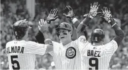  ?? CHRIS SWEDA/CHICAGO TRIBUNE ?? Albert Almora Jr. and Javier Baez congratula­te Anthony Rizzo after his grand slam.