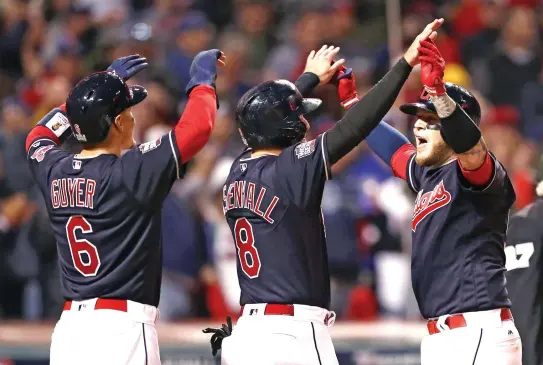  ??  ?? HIGH FIVES: Roberto Perez of the Cleveland Indians celebrates with Lonnie Chisenhall (8) and Brandon Guyer (6) after hitting a three-run home run during the eighth inning against the Chicago Cubs in Game 1 of the 2016 World Series at Progressiv­e Field...