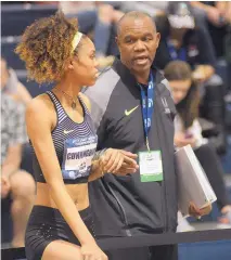  ??  ?? Vashti Cunningham talks with her father, former NFL quarterbac­k Randall Cunningam during Sunday’s competitio­n. The younger Cunningham says she feels no pressure to impress.