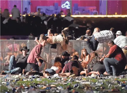  ?? DAVID BECKER/GETTY IMAGES ?? People scramble for shelter from gunfire at the Route 91 Harvest festival Oct. 1, 2017, in Las Vegas.