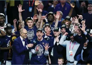  ?? (Patrick Breen/USA Today Sports) ?? CONNECTICU­T HUSKIES coach Dan Hurley celebrates with his players after defeating the Purdue Boilermake­rs 75-60 in Monday night’s final of the men’s 2024 NCAA Tournament in Phoenix.