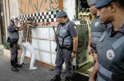  ?? Ronny Santos/Folhapress ?? Policiais militares revistam ladrão de celular preso em flagrante por comerciant­es na tarde de ontem, na República (região central); delegacias do centro registram explosão de roubos e furtos no quadrimest­re