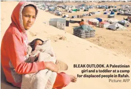  ?? Picture: AFP ?? BLEAK OUTLOOK. A Palestinia­n girl and a toddler at a camp for displaced people in Rafah.