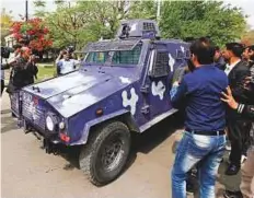  ?? AP ?? ■ Journalist­s chase a vehicle carrying a police officer, accused of killing Pashtun youth Naqeebulla­h and dozens of others suspects, following his arrest at Supreme Court in Islamabad.