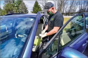  ?? The Associated Press ?? REPAIR WORK: Mike Coombs, technician at Shippee Auto, in Hinsdale, N.H., disinfects each vehicle before and after doing repairs on them to help prevent the spread of coronaviru­s on Wednesday.