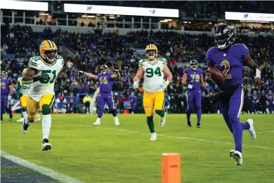  ?? The Associated Press ?? Baltimore Ravens quarterbac­k Tyler Huntley, right, rushes for a touchdown past Green Bay Packers inside linebacker Krys Barnes (51) and defensive end Dean Lowry (94) in the second half of an NFL game Sunday in Baltimore.