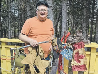  ?? ERIC MCCARTHY/JOURNAL PIONEER ?? Henry (Hank) Gallant displays flags, boots and other items that he took on his centennial walk across Canada. The backpack he is displaying is the one he used on a European walk in 1969. The one from his centennial walk is on display at the Tignish...