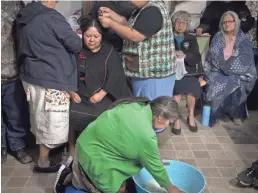  ?? PHOTOS BY MARK HENLE/USA TODAY NETWORK ?? Hours before the sunrise, Sarah Honanie, in green, mixes yucca root with water while Gloria Phillips, left, takes Kara’s hair down. When the root is mixed with water it turns into a natural shampoo. The couples’ hair was washed, then intertwine­d and washed together, bonding them in marriage. At top left, Hopi delicacies like sheep head and intestines are served during the wedding. At top right, Bunny Coriz, father of the groom, gets plastered with mud in the Hopi tradition.