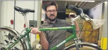  ?? MEDIANEWS GROUP ?? Zak Pashak, owner and founder of Detroit Bikes, holds a Schwinn bike frame.