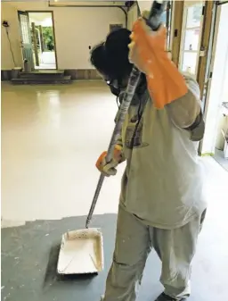  ?? COURTESY PHOTO ?? Mary Panesis helps with floor-painting duties in Triple Oak Bakery's new space.