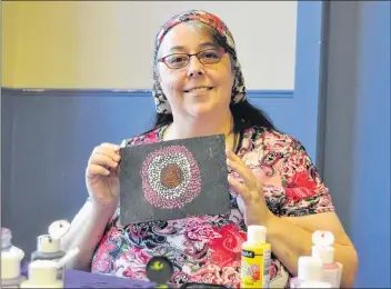  ?? SARA ERICSSON ?? Wanda Bennett and her painting of a pink, white and red mandala, made up of her favourite colours. Bennett says art has helped her through her struggles with PTSD, and has become an outlet for her.