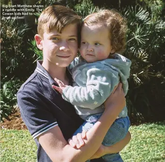  ?? ?? Big boet Matthew shares a cuddle with Emily. The Cowan kids had to grow up fast!