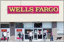  ?? (AP) ?? In this file photo, customers, some wearing face masks, line up outside a Wells Fargo branch in the Atwater Village neighborho­od of Los Angeles,
during the coronaviru­s outbreak.