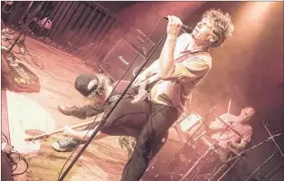  ?? PHOTO BY MARCEL LEVANDIER ?? Lead singer and guitarist Jody Richardson rides piggyback on Geoff Younghusba­nd on bass as Barry Newhook plays drums during the their reunion show at Rockhouse Saturday night. The show was a wild spectacle.