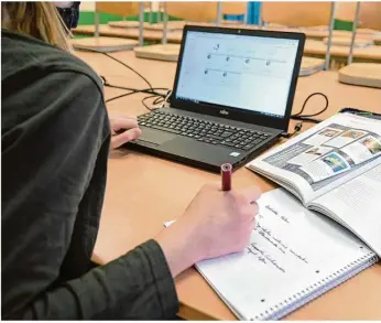  ?? Foto: Felix Kästle/dpa ?? Eine Siebtkläss­lerin des Spohn-gymnasiums in Ravensburg lernt während der Notbetreuu­ng im Klassenzim­mer am Laptop. Oft ist die Online-lernplattf­orm überlastet.