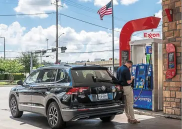  ?? — AFP ?? Falling cost: A customer at a petrol station in Houston, Texas. The price of oil has dipped in the wake of concerns that US monetary tightening to combat inflation will hurt demand and an industry report of increasing American commercial stockpiles.