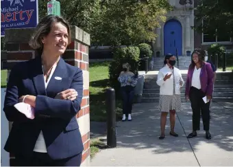  ?? Nancy Lane / HeraLd staFF ?? Annissa Essaibi-George waits to greet voters outside a polling place while Andrea Campbell, in white, talks with city councilor at-large candidate Ruthzee Louijune.