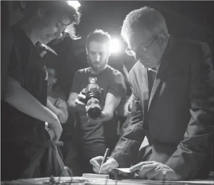  ?? CHRIS YOUNG, THE CANADIAN PRESS ?? NDP MP Charlie Angus signs a book for a supporter after announcing his intention to run for the NDP federal leadership at a rally in Toronto. Angus has said he wants to find out what New Democrats are thinking before he comes up with specific policy...