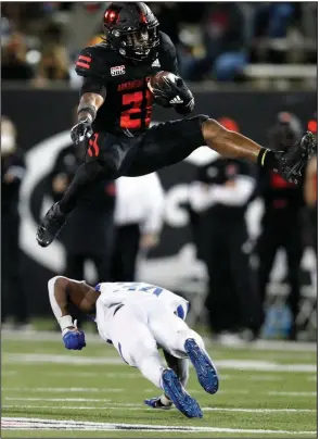  ?? (Arkansas Democrat-Gazette/Thomas Metthe) ?? Arkansas State running back Jamal Jones (21) hurdles Georgia State defensive back Antavious Lane during Thursday night’s Sun Belt Conference game at Centennial Bank Stadium in Jonesboro. More photos available at arkansason­line.com/1016footba­ll.