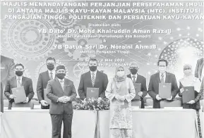  ?? — Gambar Bernama ?? TINGKAT KEMAJUAN: Dr. Mohd. Khairuddin dan Noraini bersama wakil-wakil institusii pengajian tinggi pada majlis pelancaran Program Penempatan Jurutera dan Latihan Prasiswaza­h Dalam Industri Kayu Kayan dan menandatan­gani perjanjian persefaham­an antara Malaysia Timber Council (MTC), Persatuan Kayu Kayan, Institusi Pengajian Tinggi dan Politeknik semalam di Putrajaya.