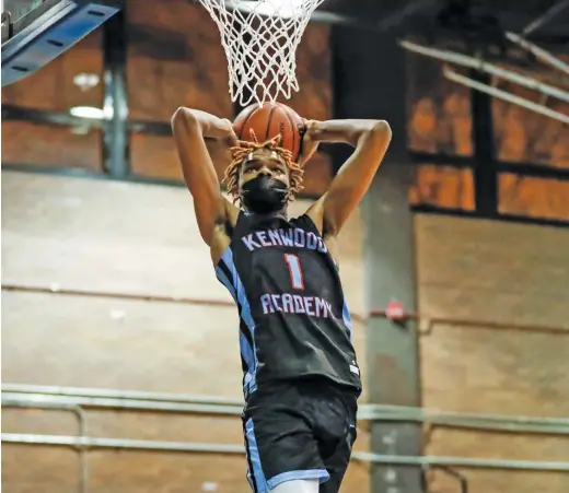  ?? KIRSTEN STICKNEY/SUN-TIMES ?? Kenwood’s JJ Taylor slams home two of his 41 points Wednesday against Clemente. He sank eight three-pointers in the game.