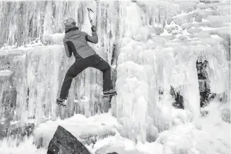  ?? Associated Press ?? ■ An ice climber tackles a frozen waterfall Saturday high up in Brecon Beacons National Park in Wales. Wales has been particular­ly hard-hit by the unusually cold weather gripping much of Europe, with prediction­s that the deep freeze will continue for...