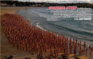  ?? AFP PHOTO ?? SUNRISE STRIP Participan­ts pose nude at sunrise on Sydney’s Bondi Beach for United States art photograph­er Spencer Tunick to raise awareness about skin cancer on Saturday, Nov. 26, 2022.