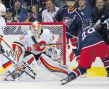  ?? KIRK IRWIN/GETTY IMAGES ?? Goalie Chad Johnson makes one of his 34 saves on Columbus Blue Jackets forward Brandon Saad Wednesday during the Flames’ 2-0 win at Nationwide Arena in Columbus, Ohio.